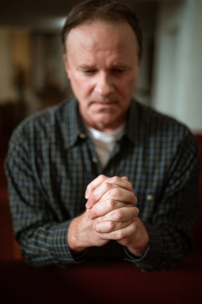 Close-up of a man in deep prayer inside a church, symbolizing faith and devotion.
